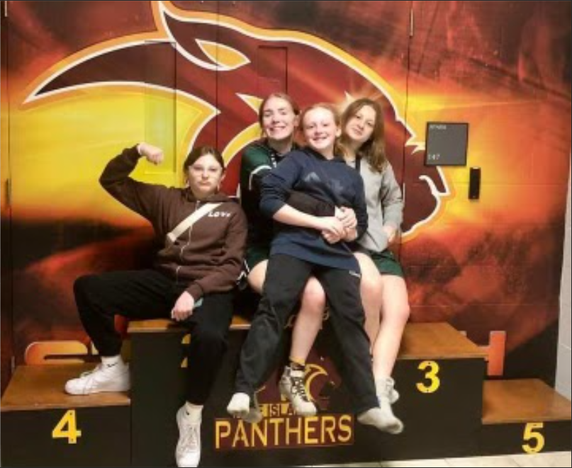 Scarlet Benner, Tegan Erickson, Leah Connolly, and Hallie Malenke posing for a wrestling tournament (Left to Right)