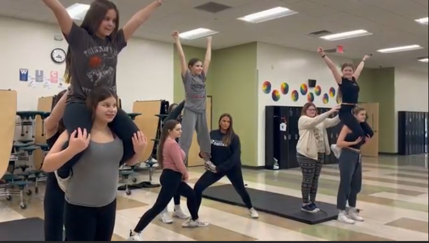Spectrum cheer members performing a stunt cheer during practice