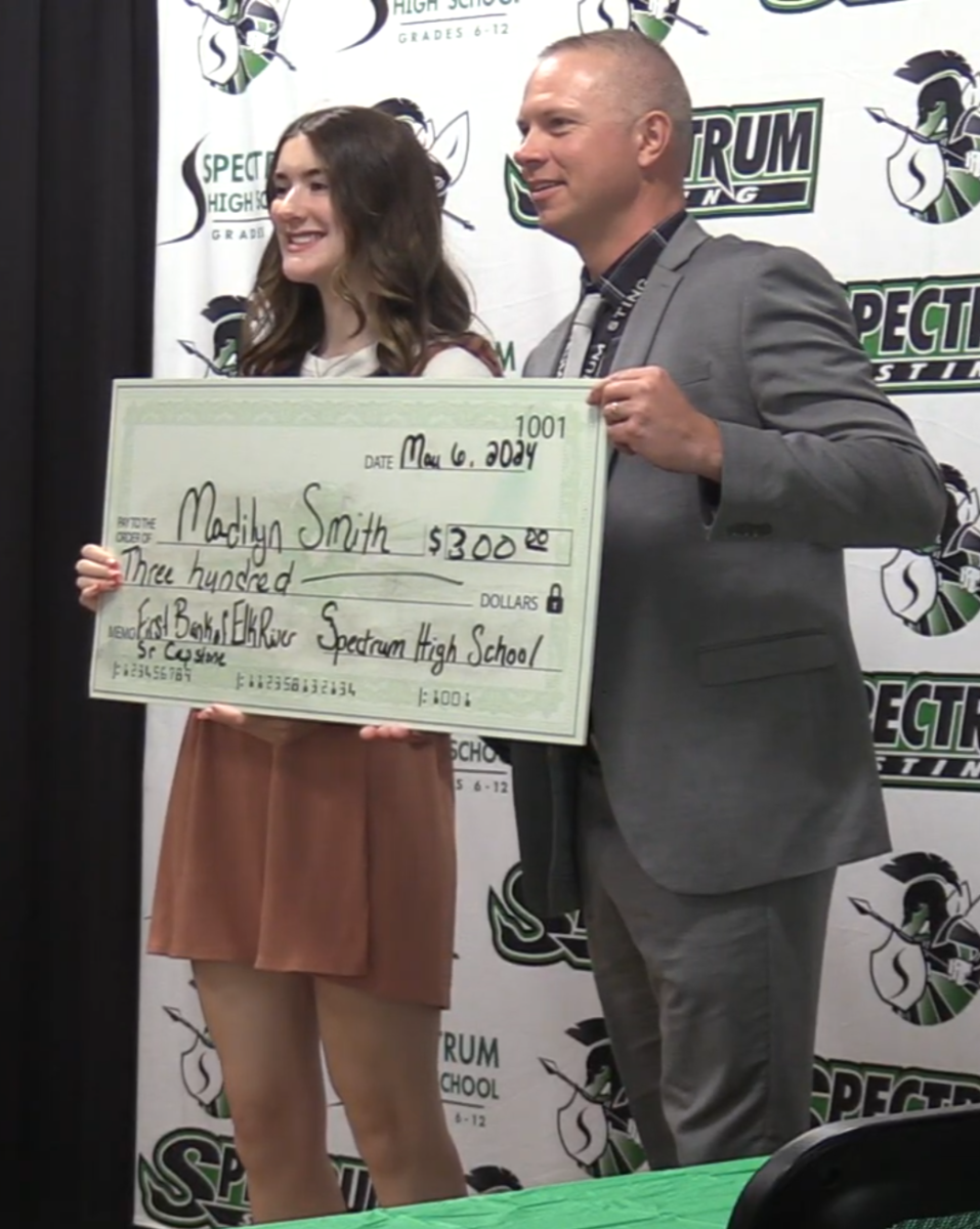 Madilyn Smith accepting scholarship check from Mark Leland.