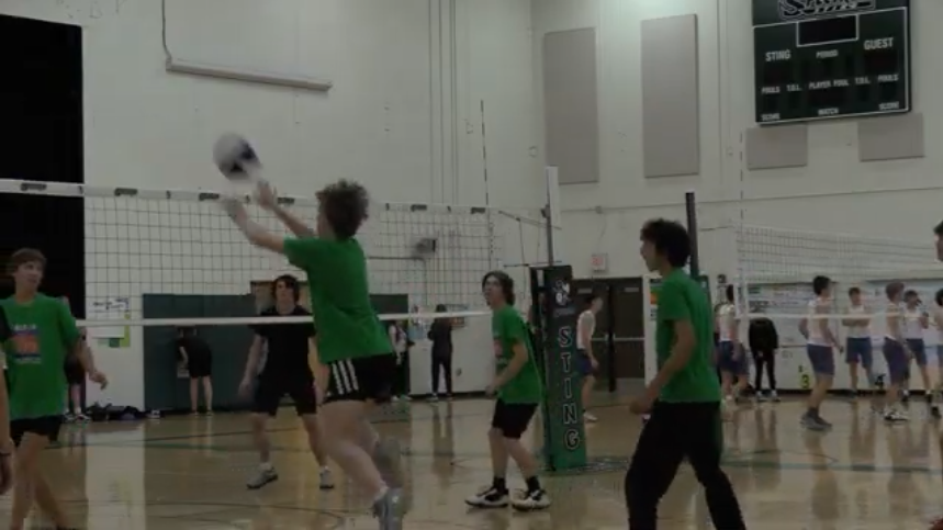 The boys sophomore team hits the ball over the net during their first game of the powdertuff tournament