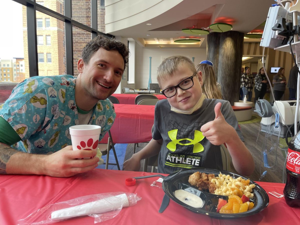 Aidden eating Chick-Fil-A with a hospital staff.