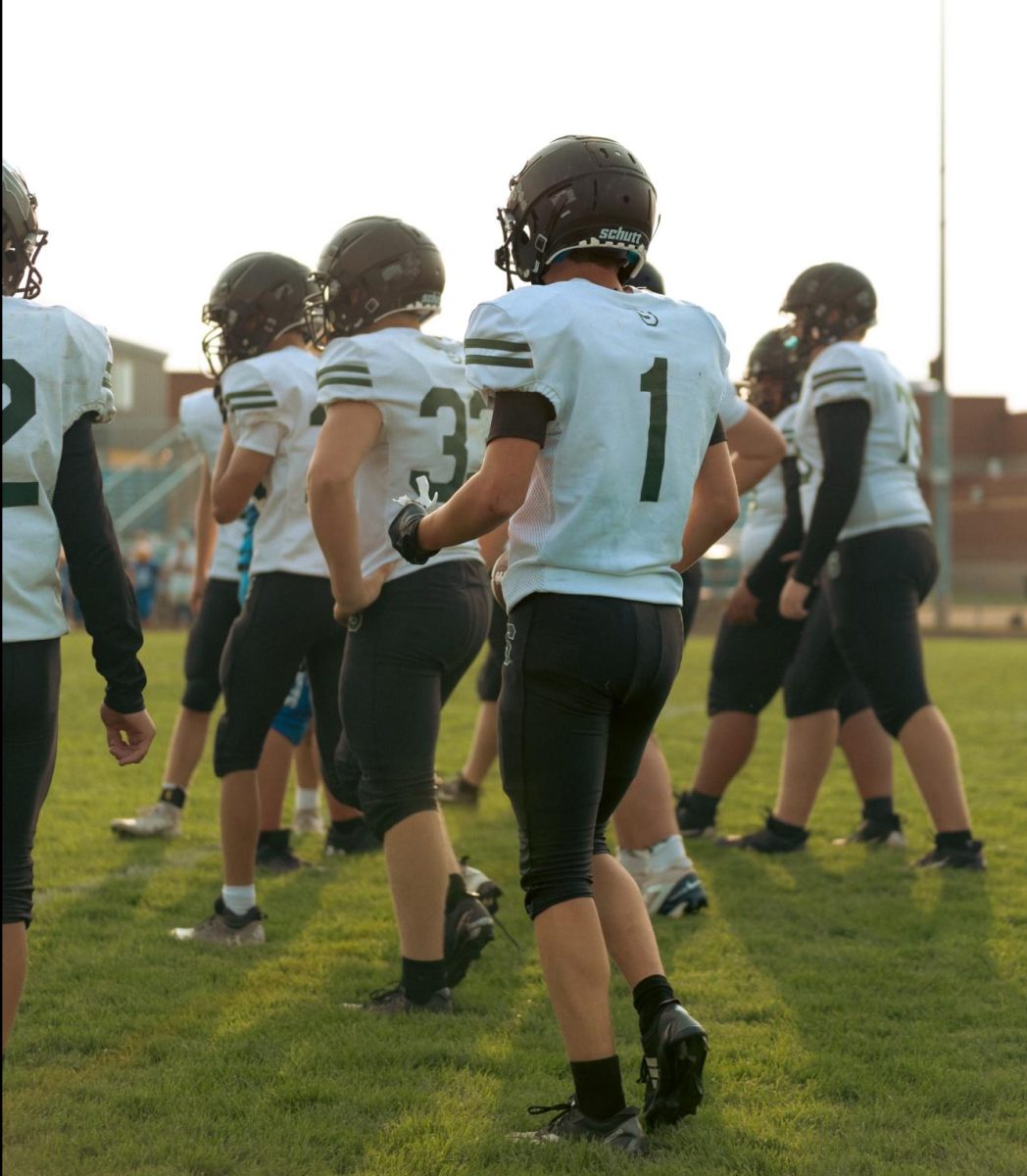 Spectrum varsity football team coming together during their game, 2025.