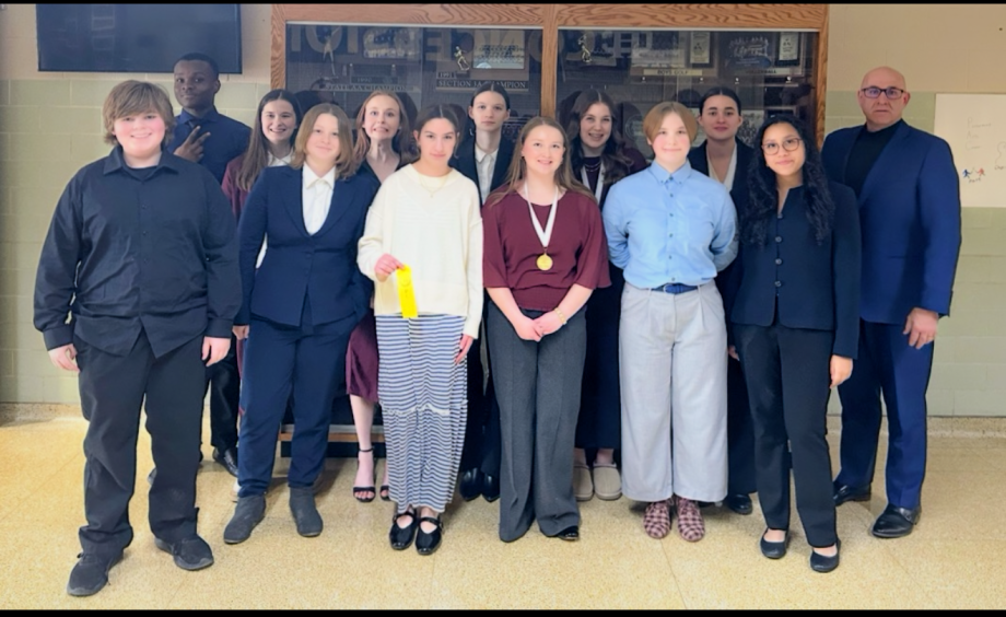 The Speech team at a competition this season, posing with their awards.