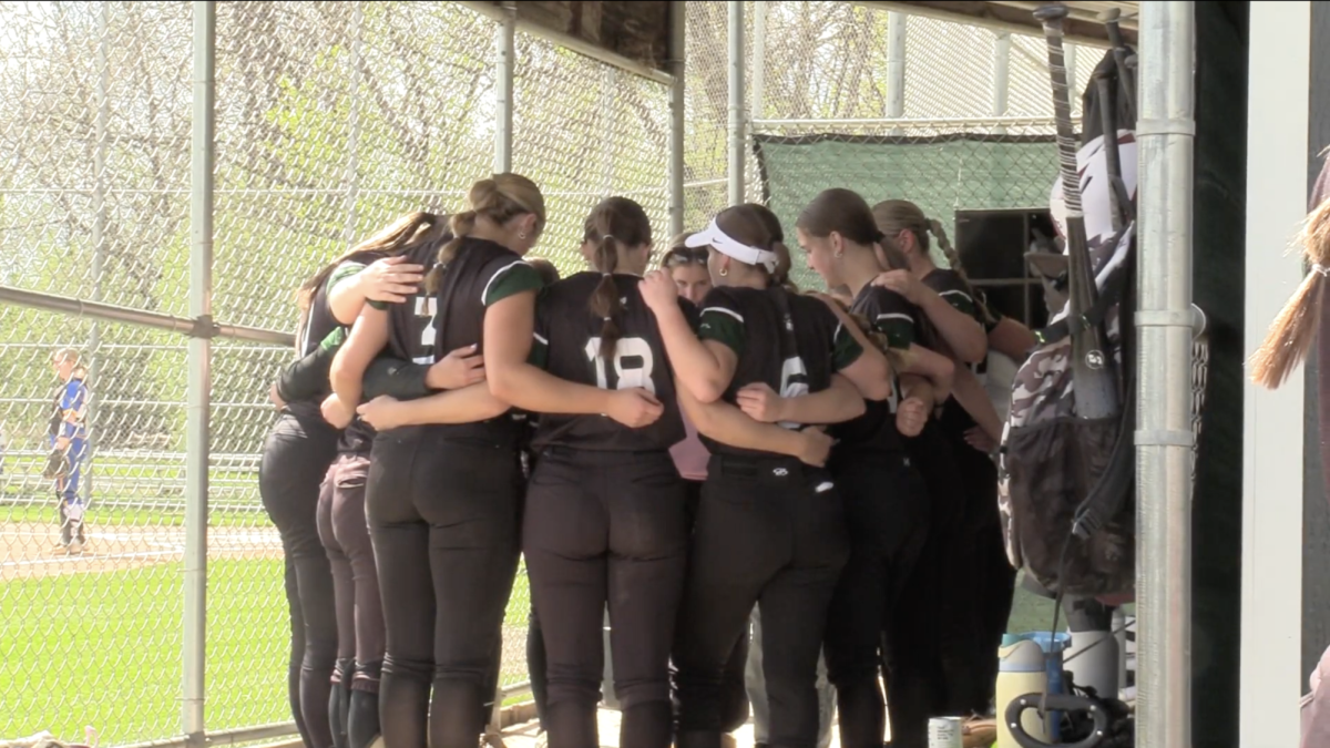 The softball team huddling together at recent game (Makayla Taylor)